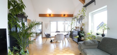lichtdurchflutetes Wohnzimmer mit hoher Decke und Zugang zum Balkon