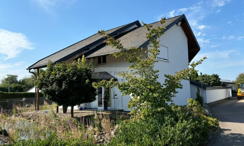 Freistehendes Einfamilienhaus mit Wärmepumpe und Option auf anmietbare Gewerbehalle zu verkaufen.