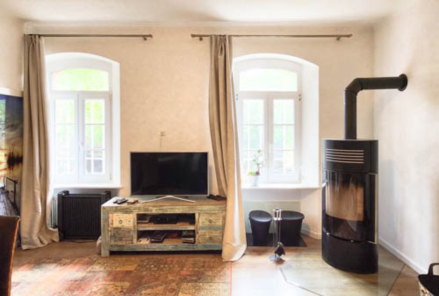 Stilsicher renoviertes Wohnzimmer mit gemütlichem Kaminofen im Erdgeschoss
