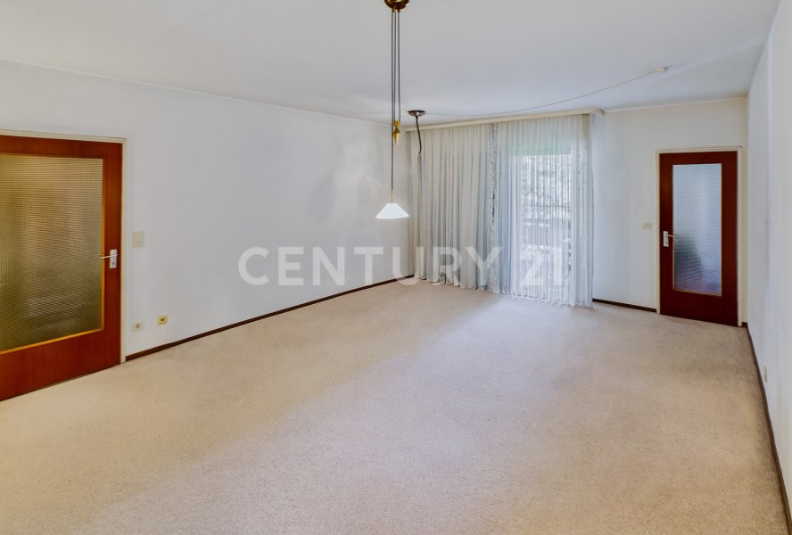 Wohnzimmer mit Blick zum Balkon und zur Küche